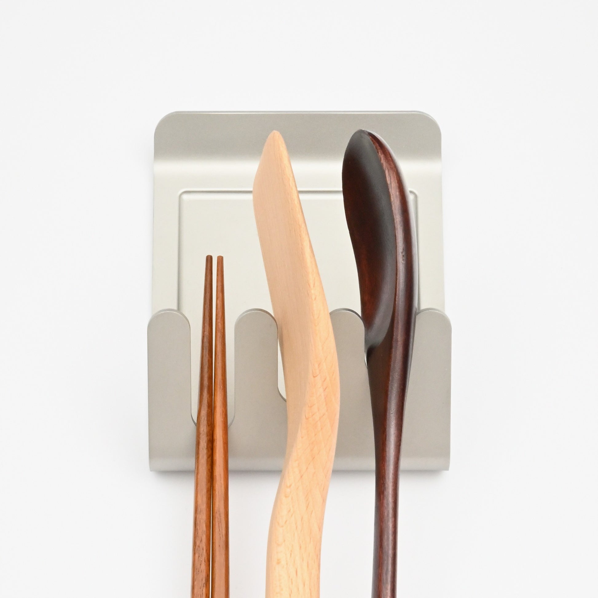 Alto holding chopsticks, a wooden spatula, and a spoon in its three slots